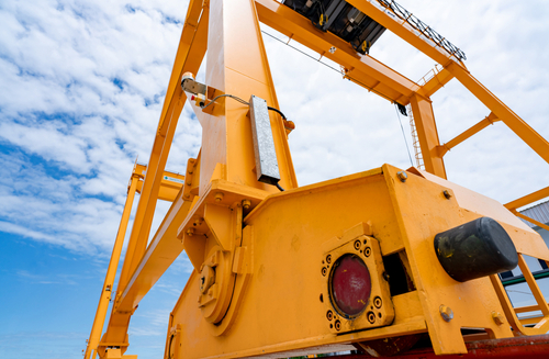 Blurred,yellow,gantry,crane,against,blue,sky,at,port.,gantry